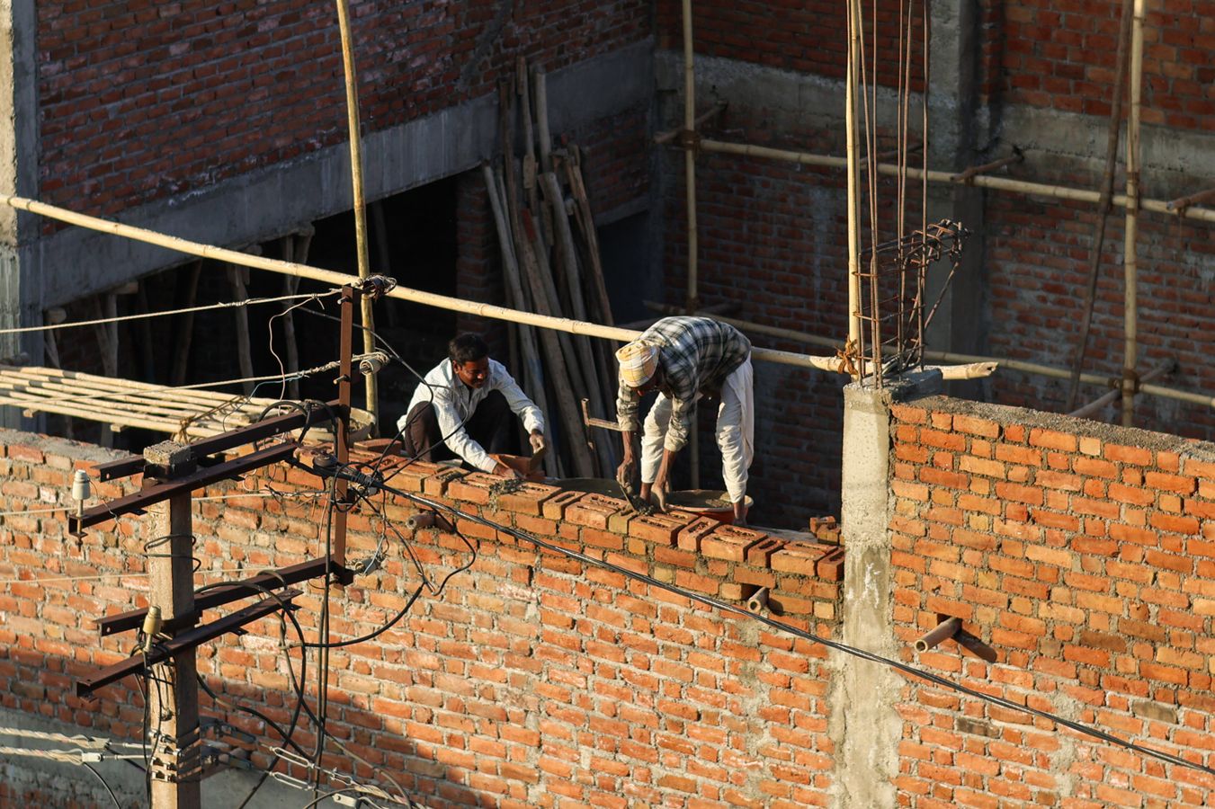 Bricklayer applying mortar to a brick wall on a job site