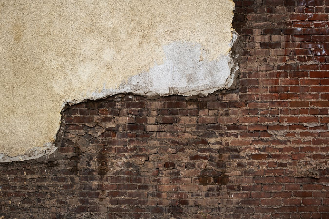 Close-up of a mason repairing and repointing a brick wall with a trowel