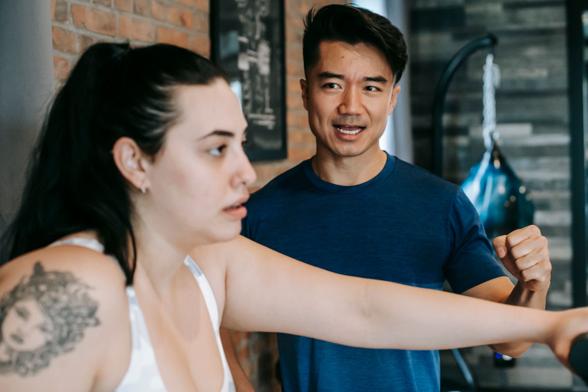 Personal trainer guiding client through a strength session at the gym