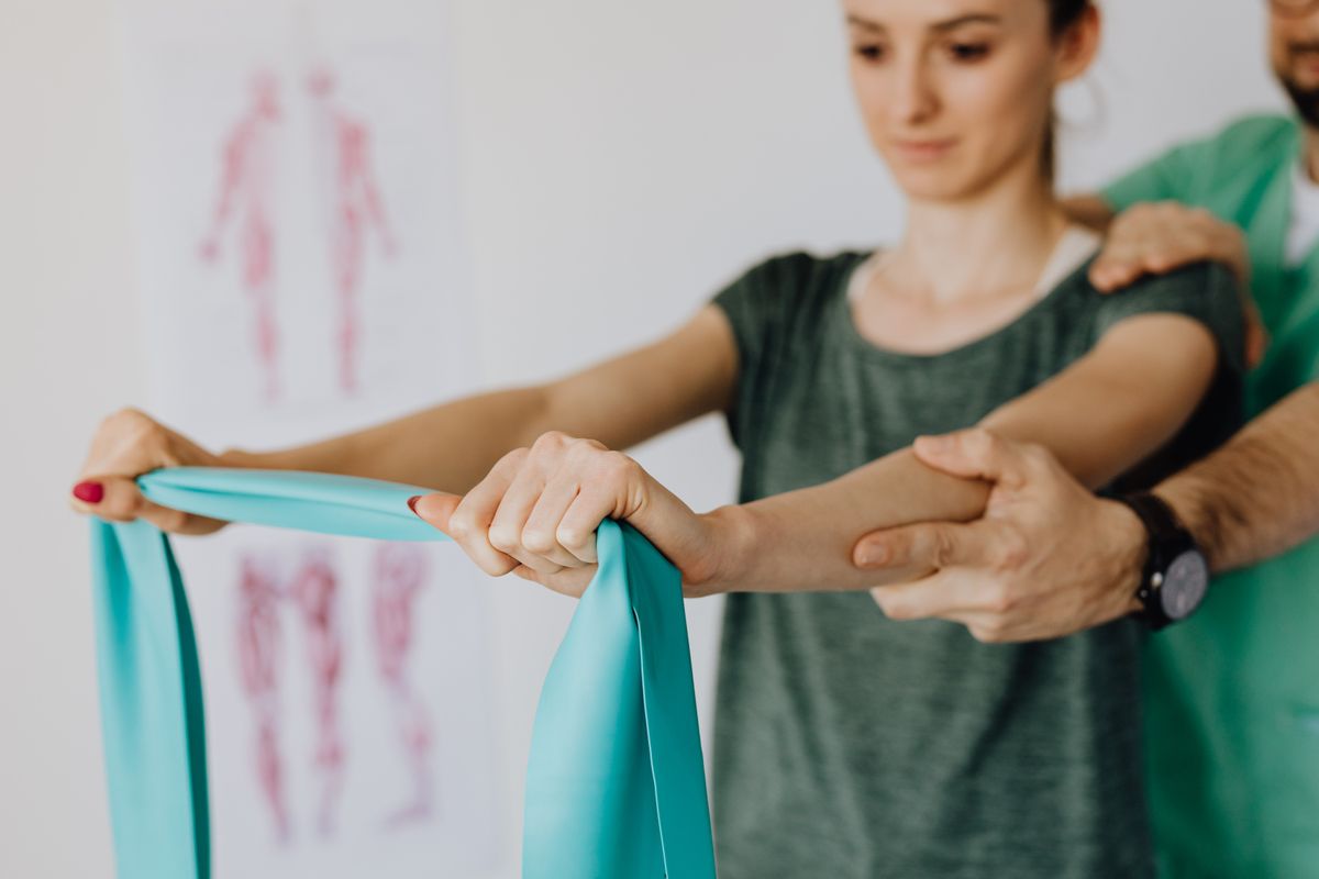 Physical therapist assisting a patient with shoulder rehabilitation exercises