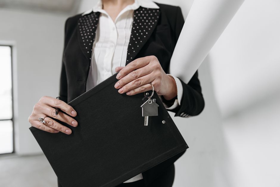 Property manager holding house keys and a clipboard with a lease document