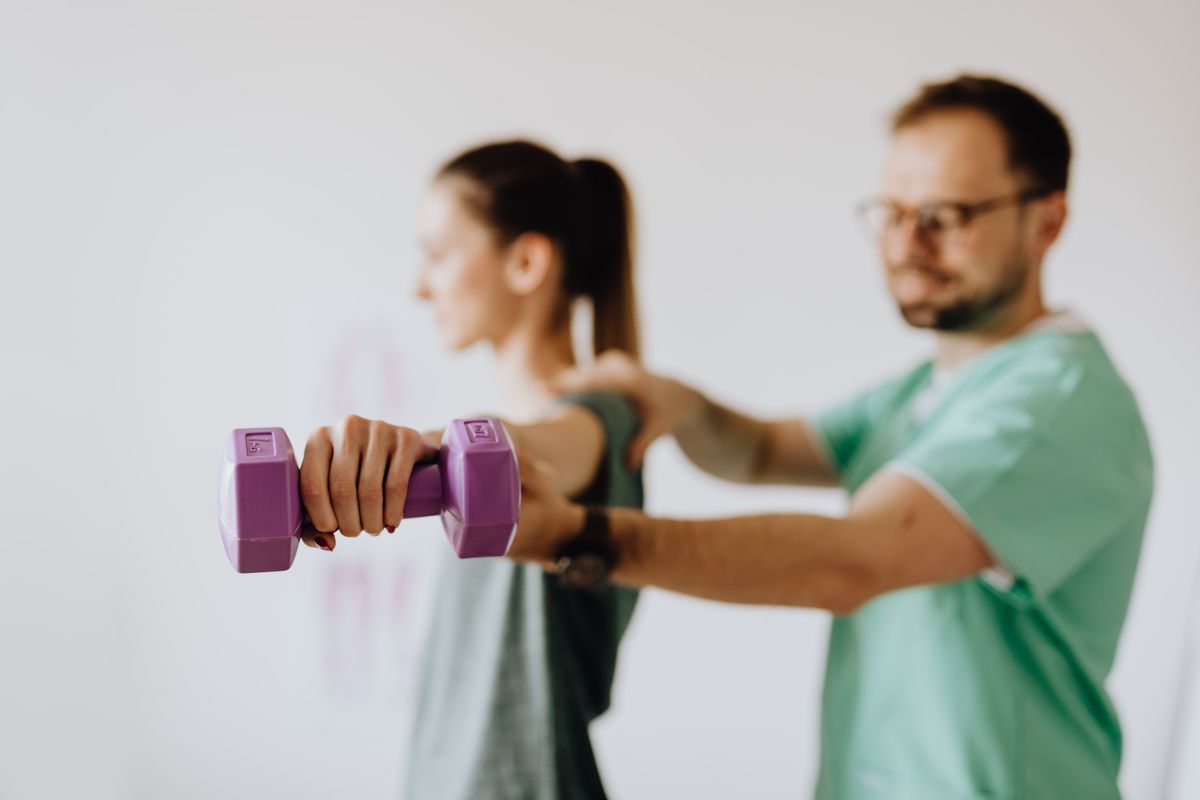 Physical therapist guiding patient through strength training exercises