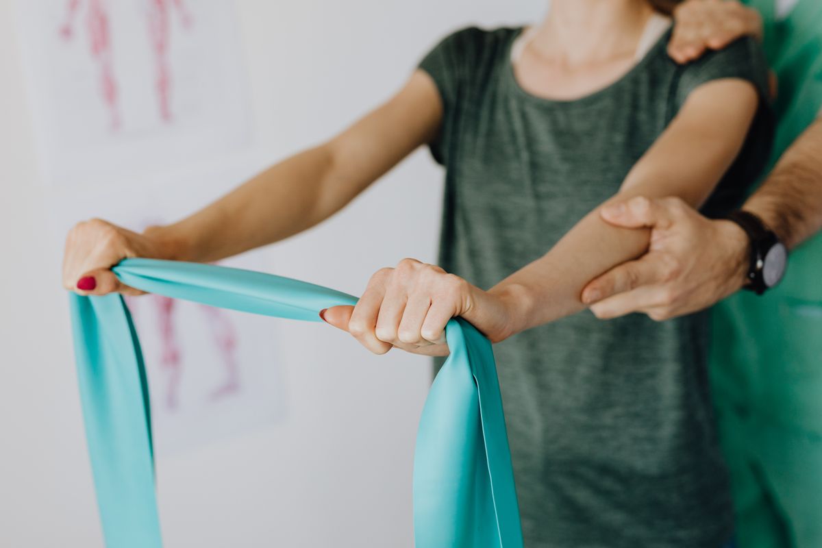 Physical therapist helping patient with leg stretching and flexibility