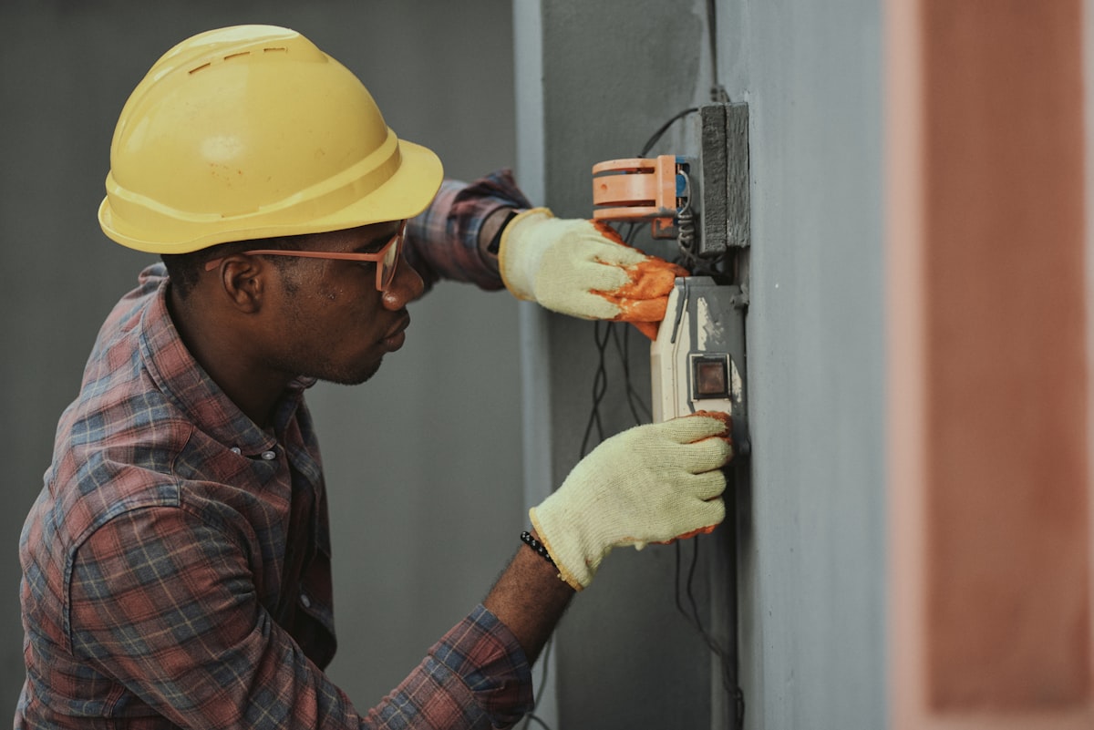electrician installing wiring with yellow hardhat safety equipment
