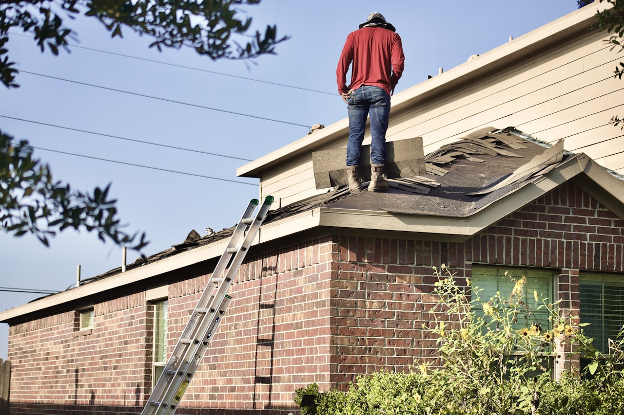 roofer standing on residential roof inspecting shingles