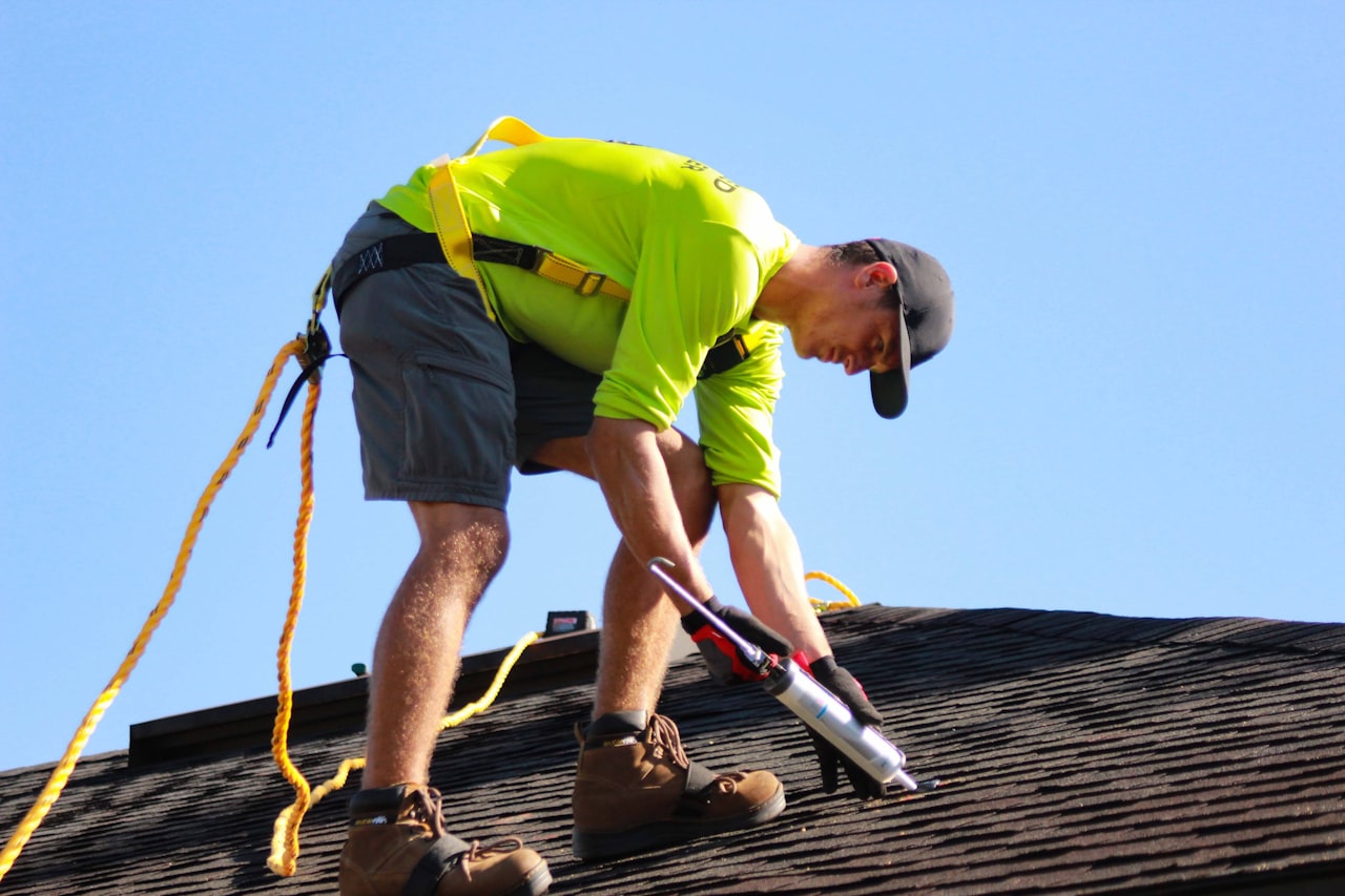 roofer in yellow shirt installing roofing materials