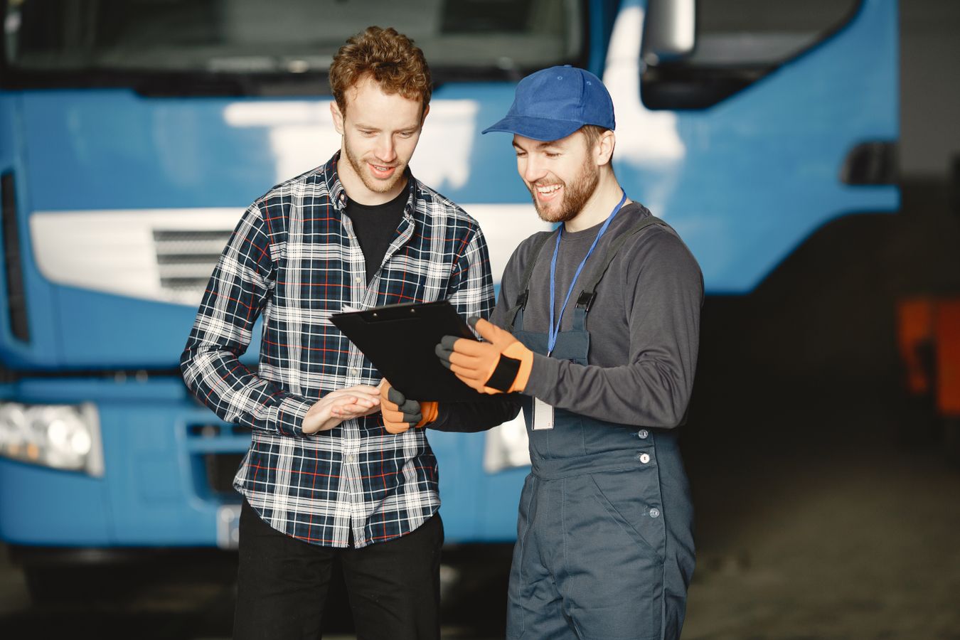 Two service technicians reviewing paperwork next to a service truck before a job