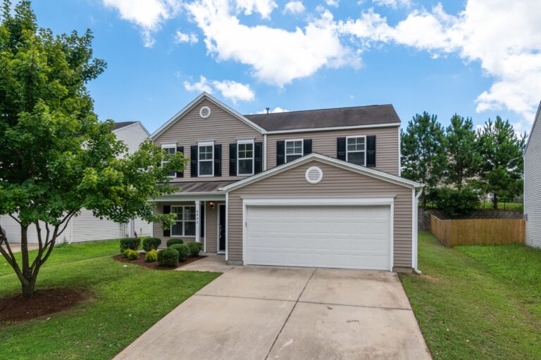 Two-story suburban home with new siding and green lawn
