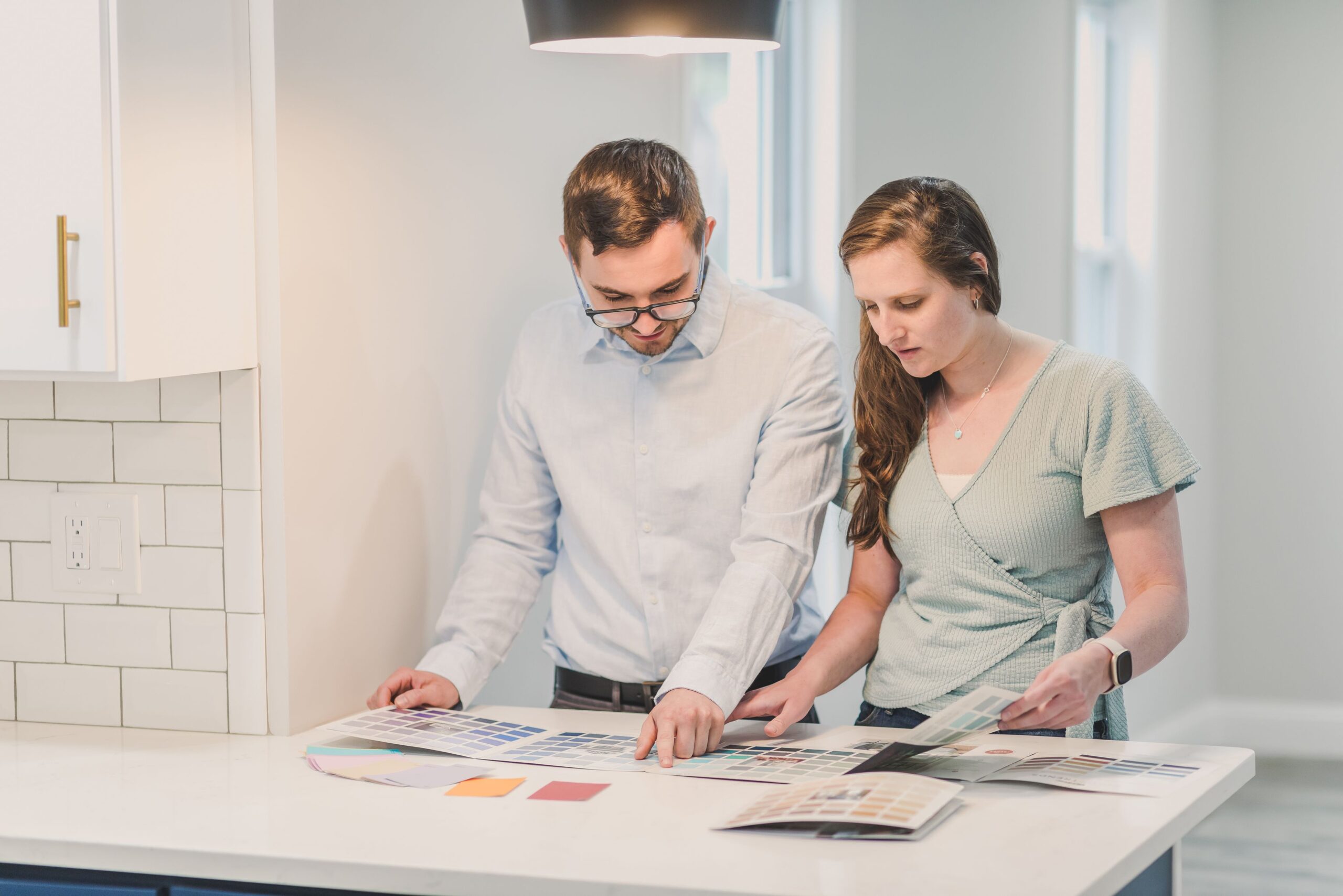 Homeowners comparing siding color swatches during a planning consultation