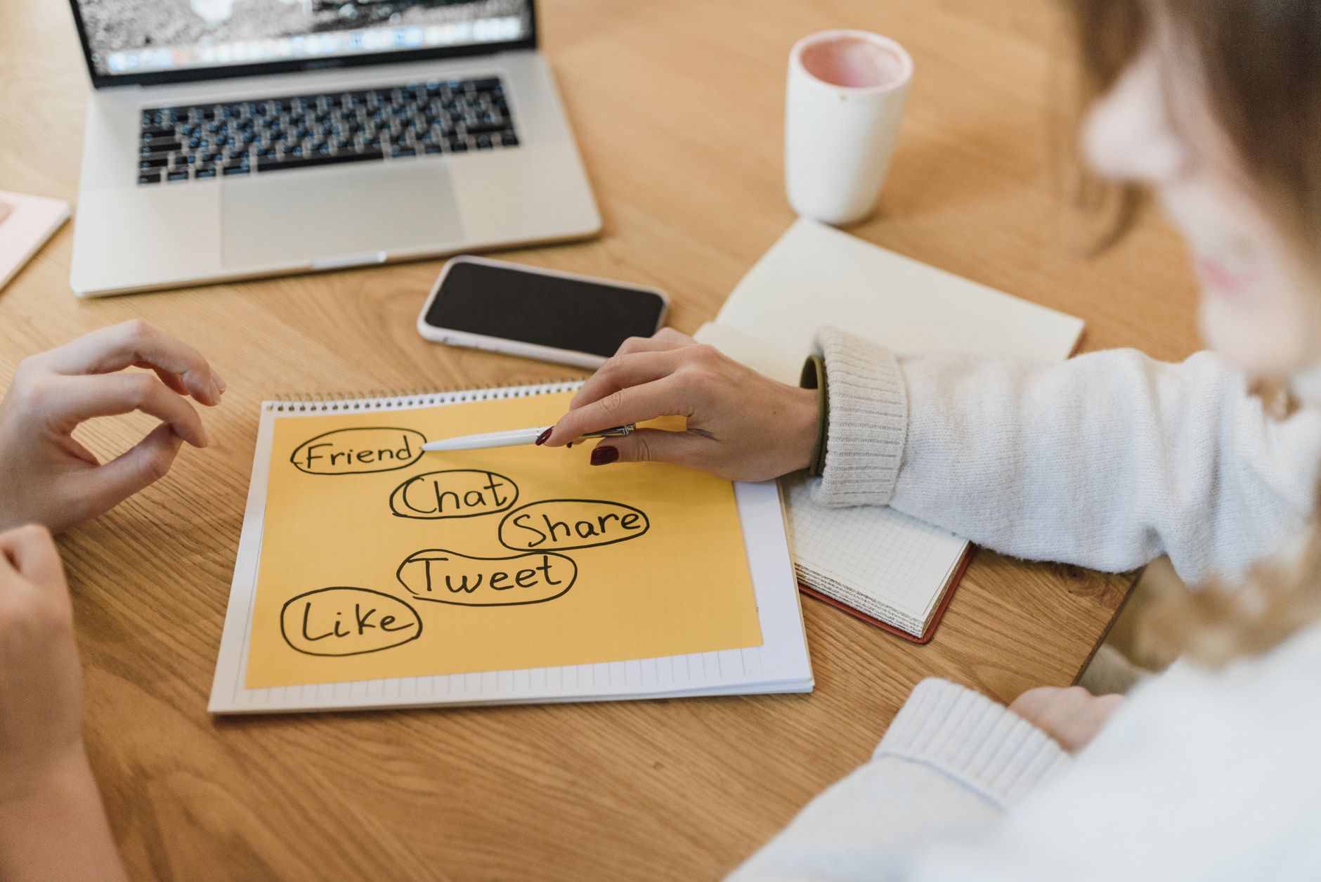 Two small business owners reviewing a content planning session with documents spread across a desk