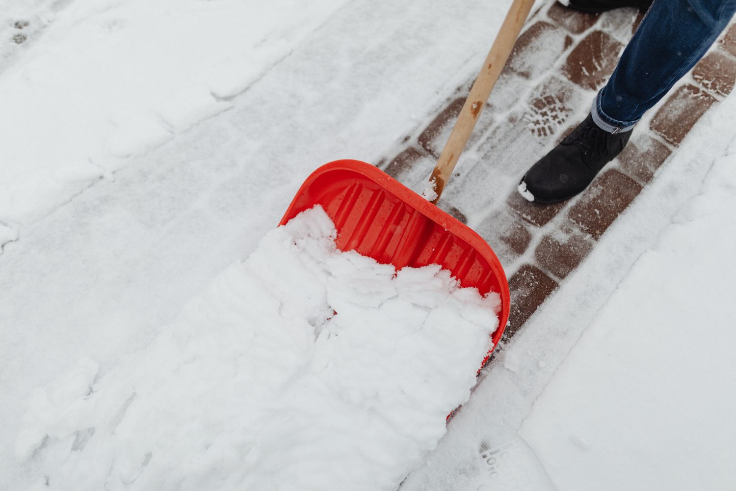 Homeowner shoveling snow from a residential driveway in winter