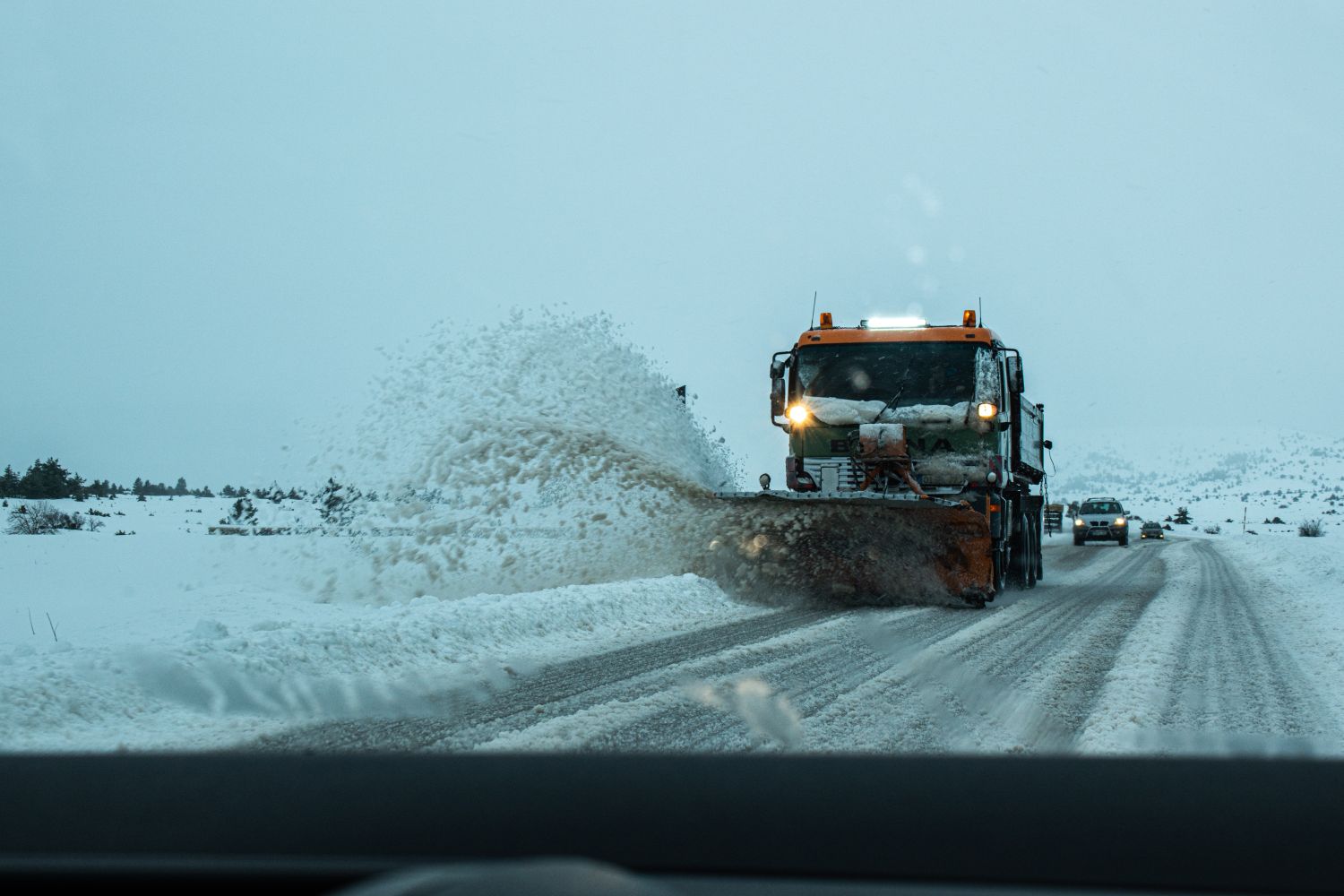 Salt spreader attachment on a winter service truck preparing for a storm