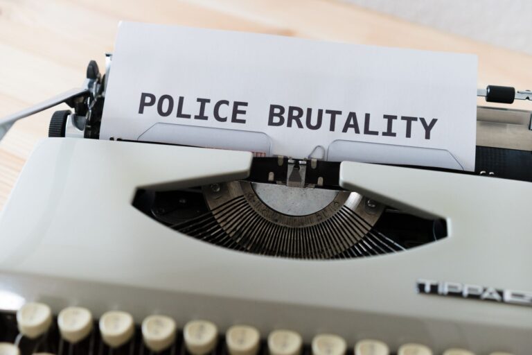 Close-up of a typewriter with the text 'POLICE BRUTALITY' on paper, highlighting the message of awar