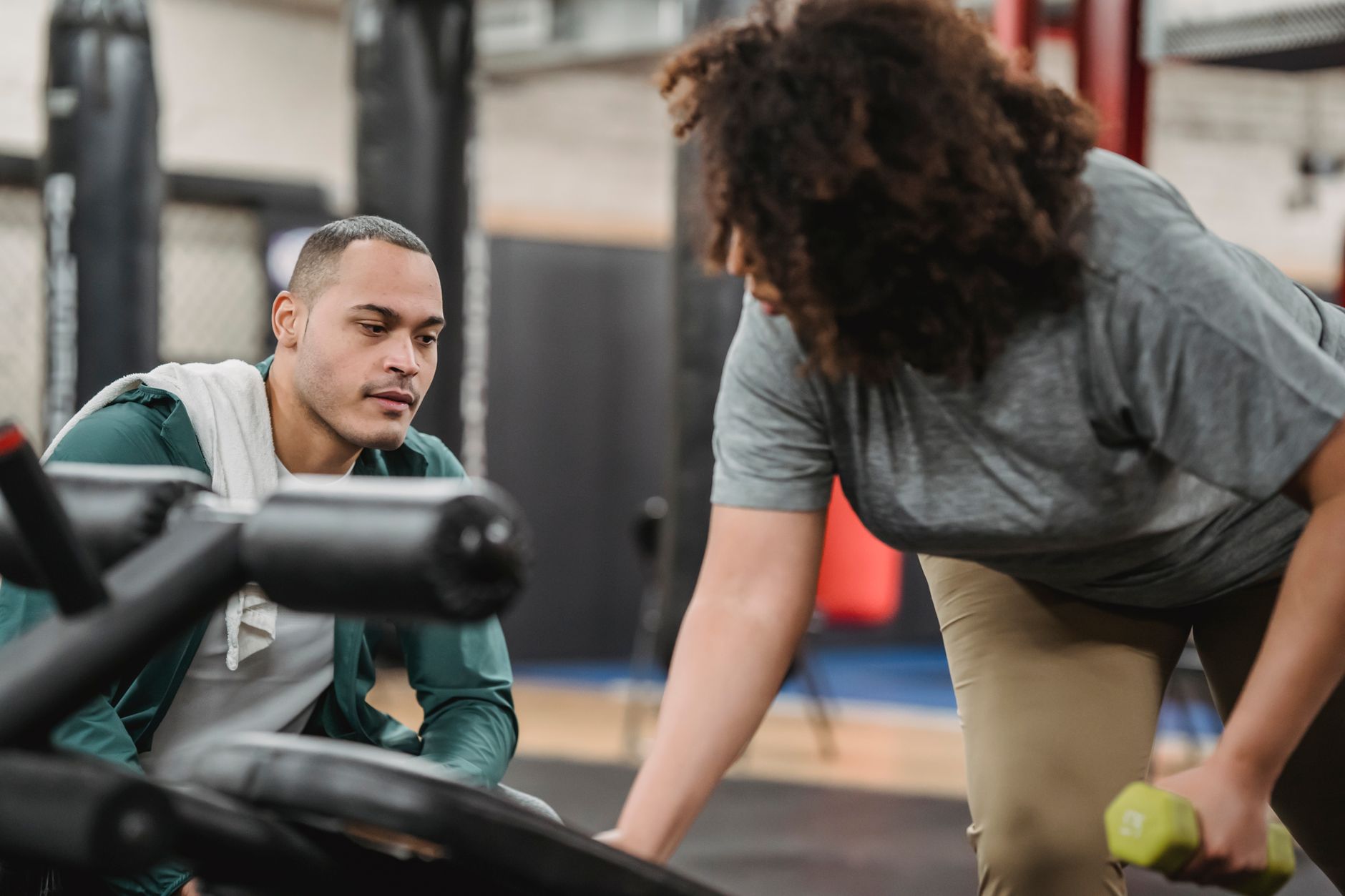 Personal trainer instructing client on dumbbell exercise form
