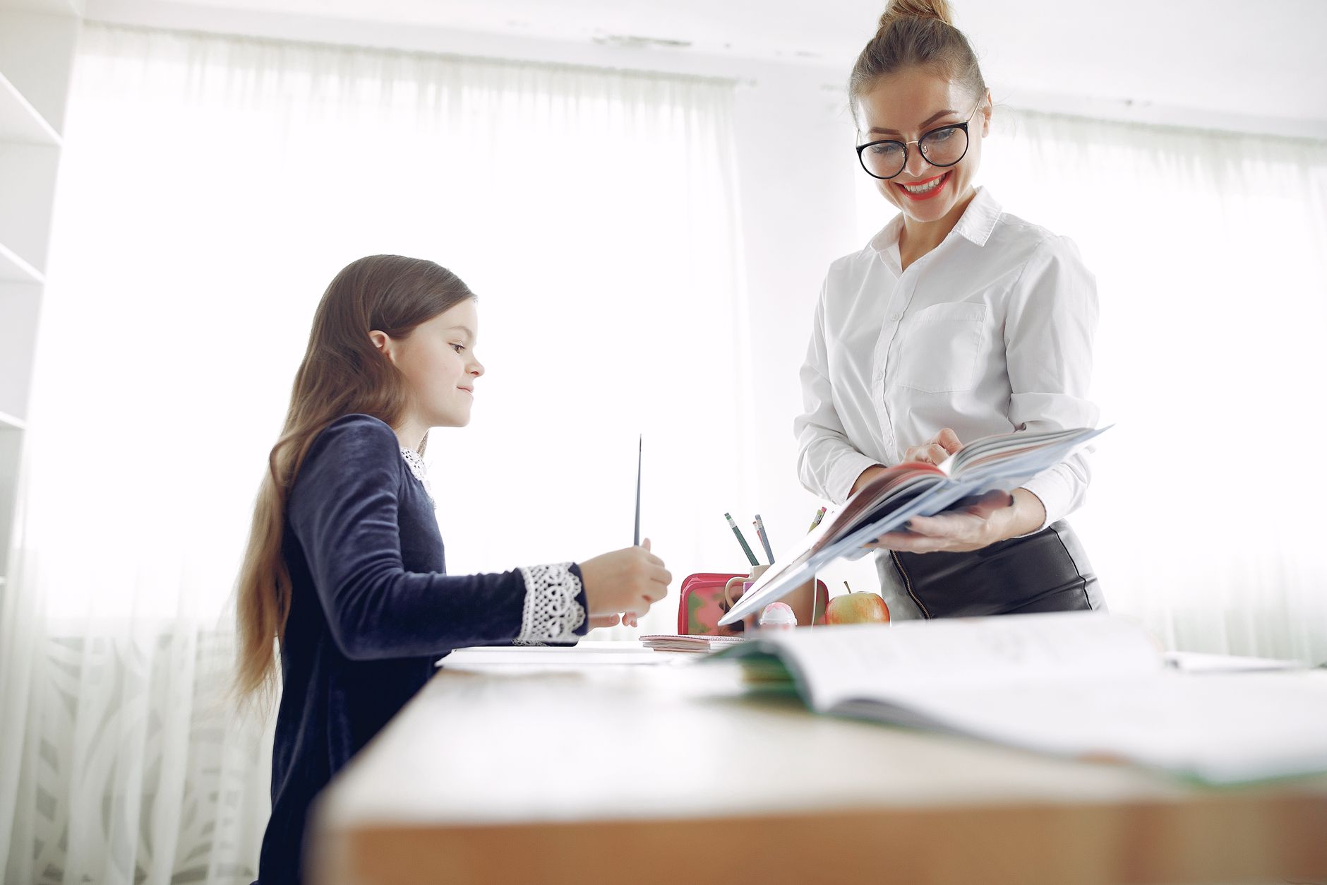 Happy tutor guiding a young student through a lesson with a smile