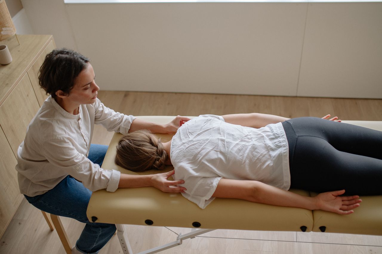 Physical therapist performing manual therapy on a patient's back on a treatment table