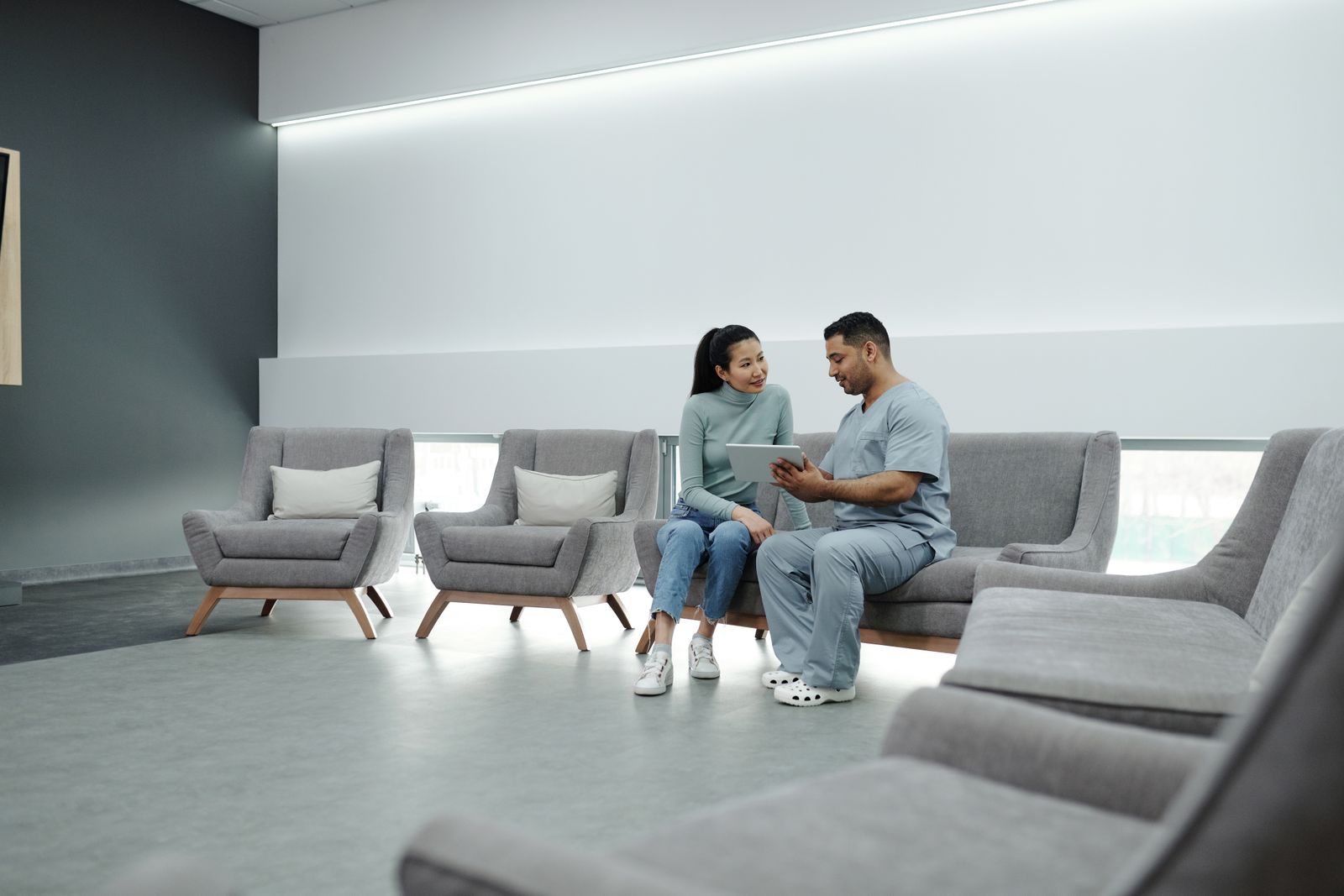 Urgent care provider reviewing a patient visit on a tablet in the waiting area