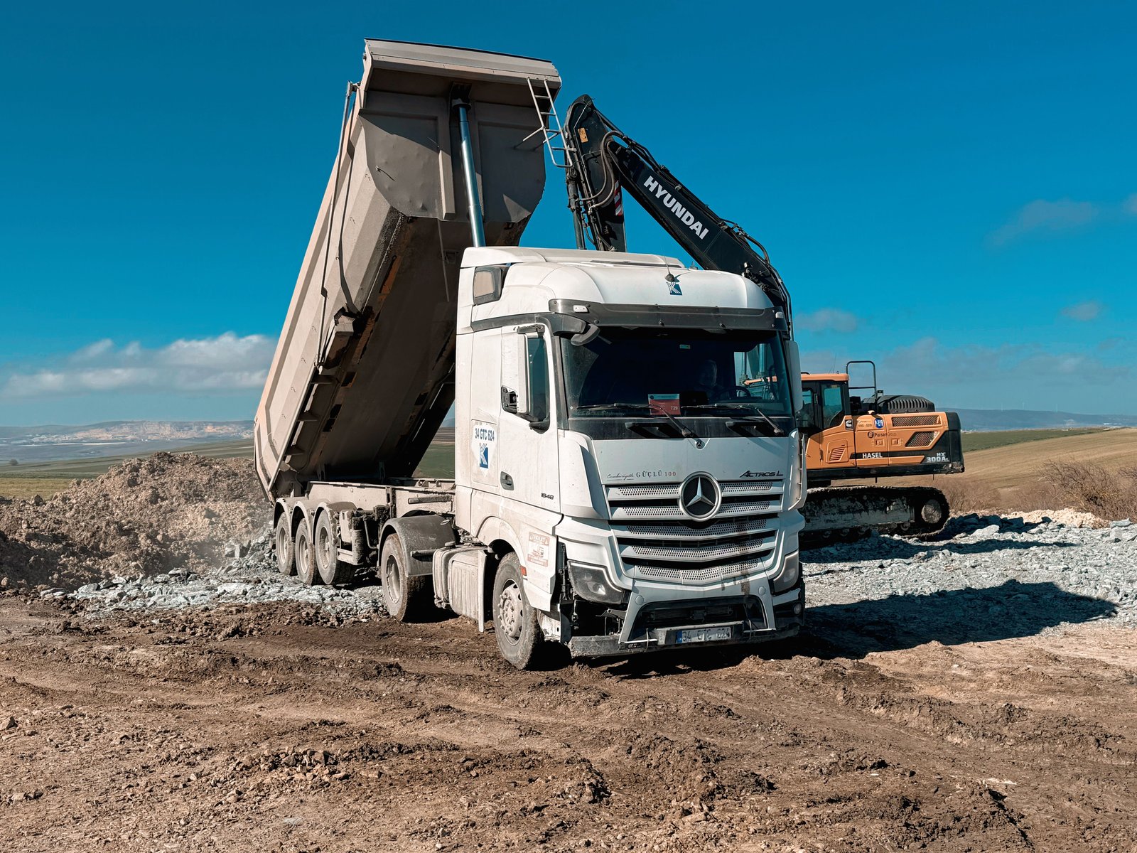 Dump truck and excavator working together to haul material off a grading site