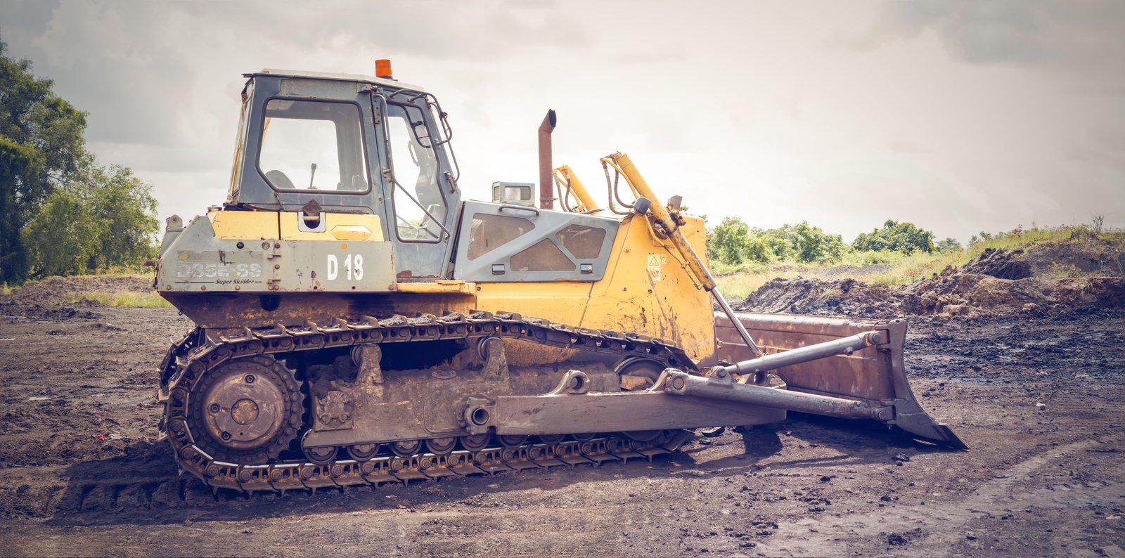 Bulldozer clearing and grading raw land at a job site
