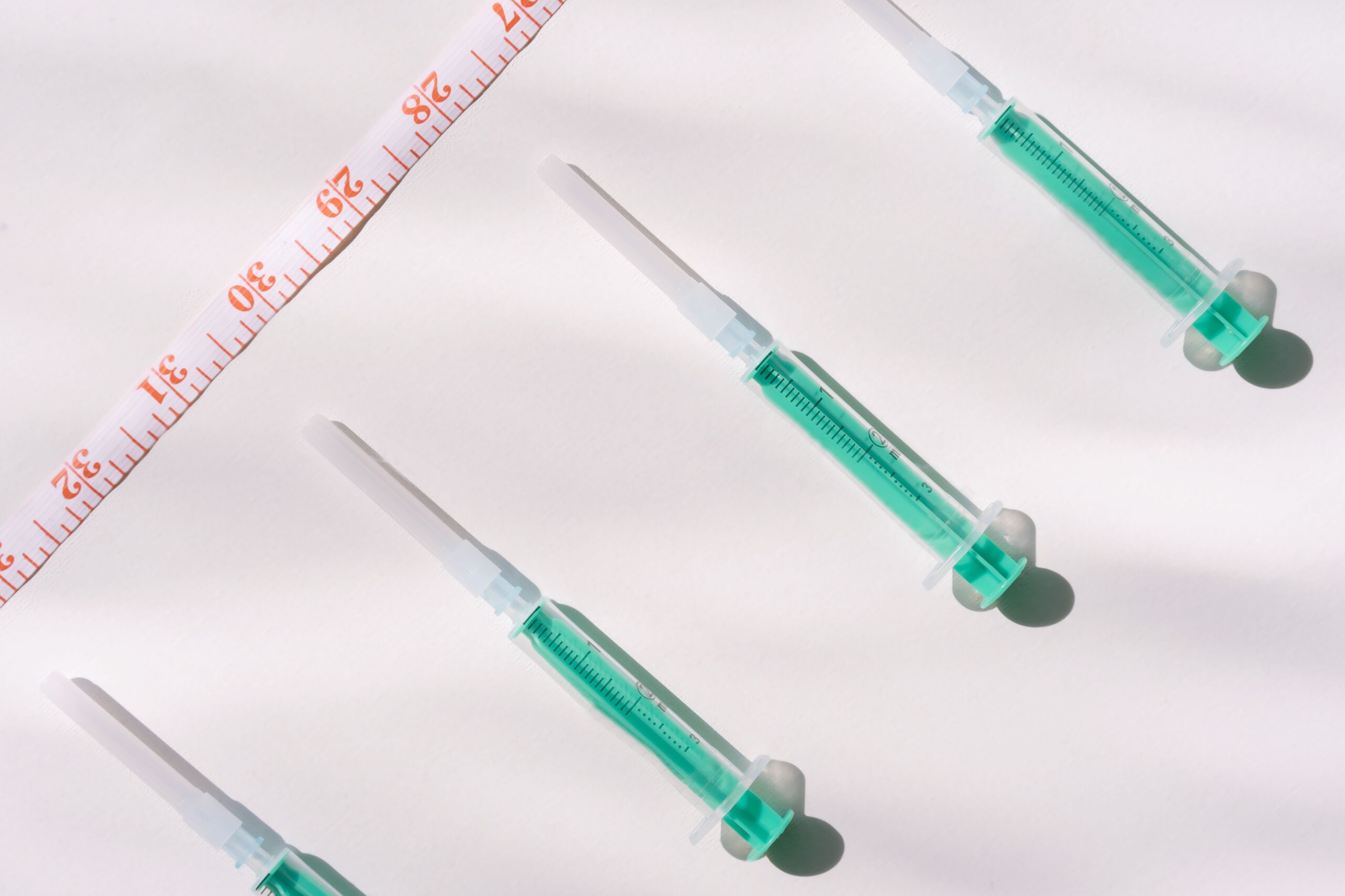 GLP-1 injection pens and a measuring tape representing medical weight loss treatment