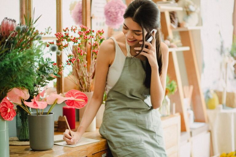 Small business owner talking on the phone while managing her shop