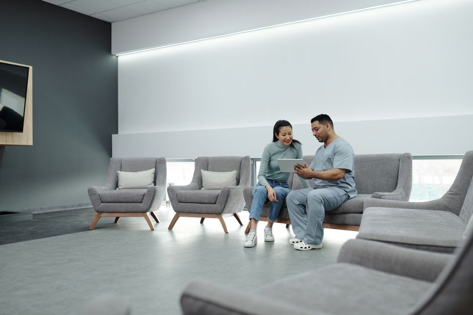 Doctor in scrubs consulting with a patient in a fertility clinic waiting area
