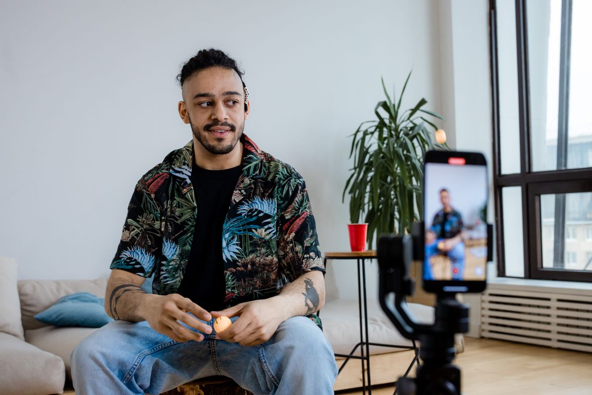 Person recording a short vertical video with a smartphone on a tripod
