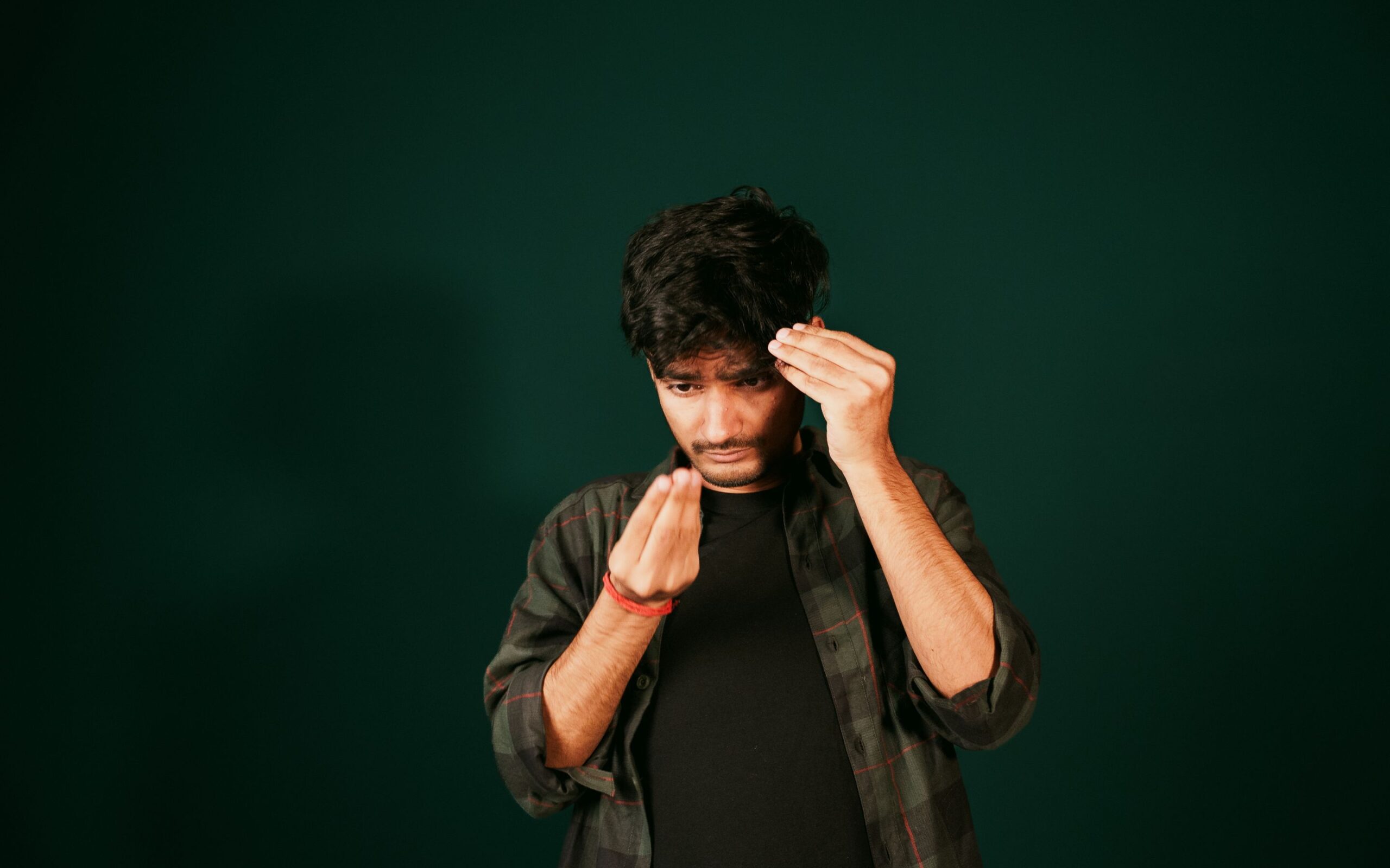 Young man examining his hairline in a mirror, checking for signs of thinning