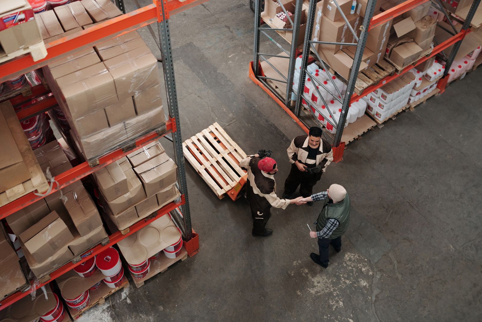 Two warehouse workers shaking hands, representing an injured employee returning to work after a workers compensation claim