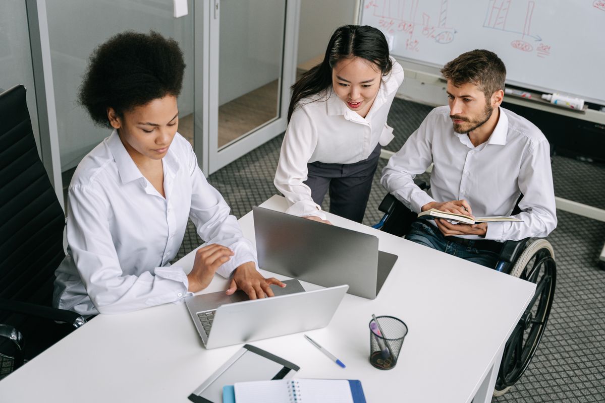 A disability law team including a wheelchair user collaborating in a modern office