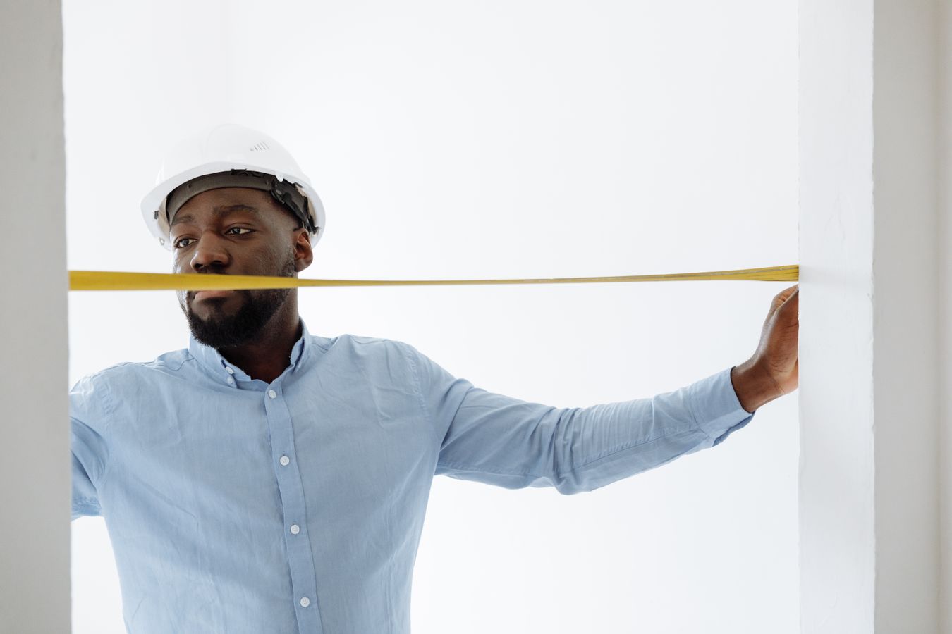 Contractor measuring a window frame with a tape measure during installation