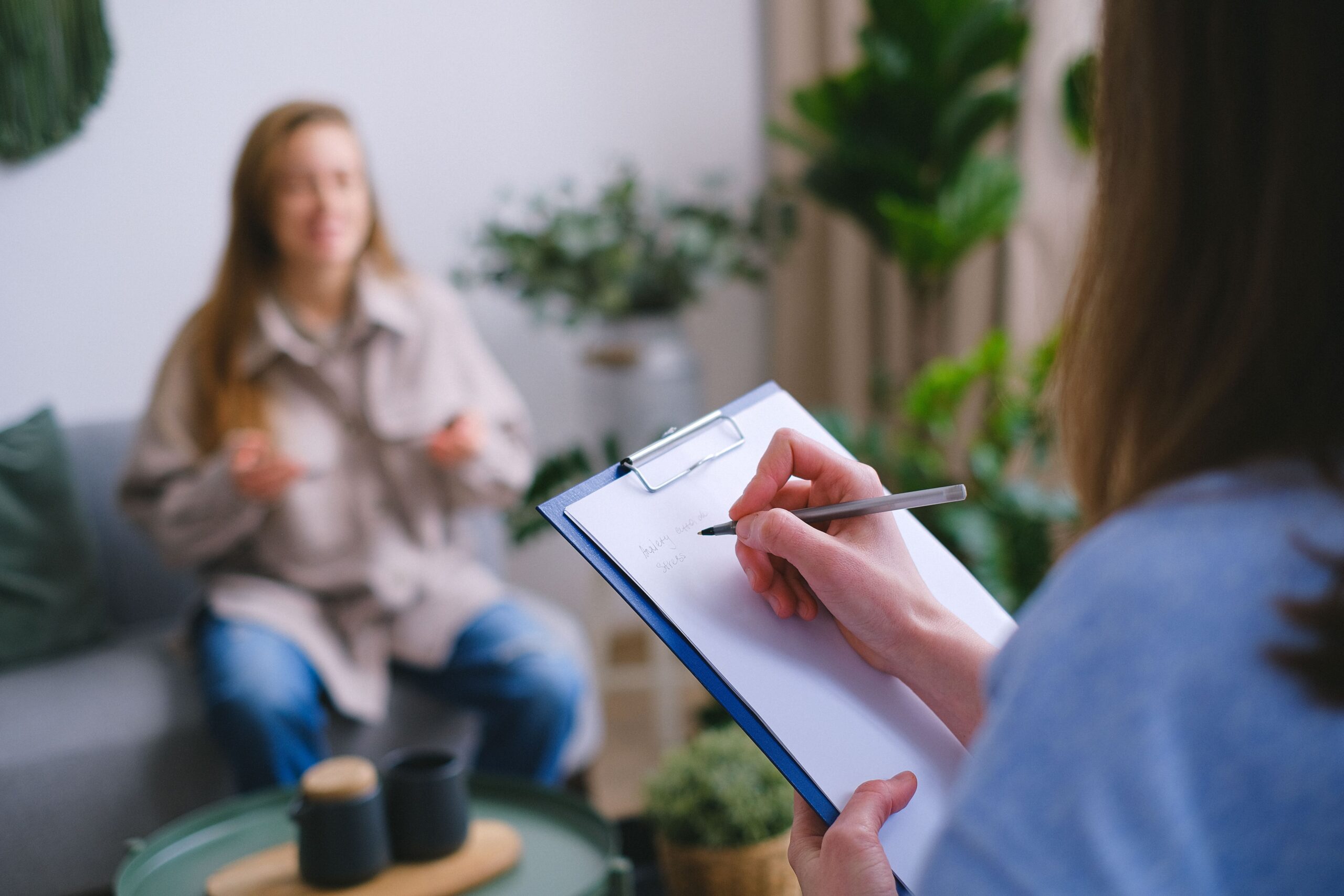 A therapist taking notes during a counseling session