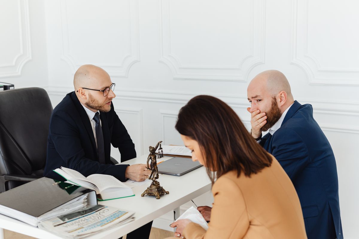 An attorney holding a serious legal consultation with a client about a disability case