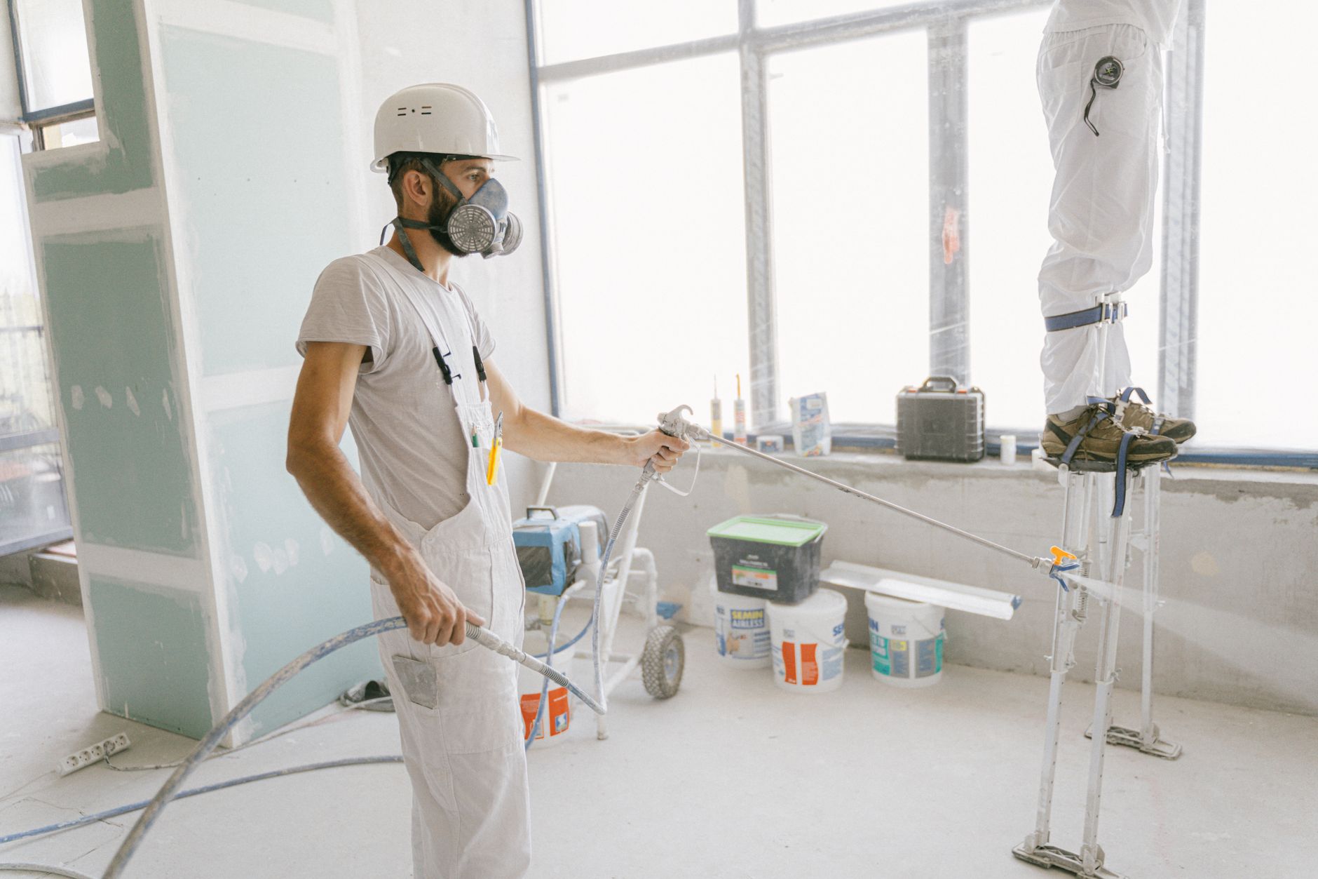 Contractor applying spray foam insulation during a home energy upgrade
