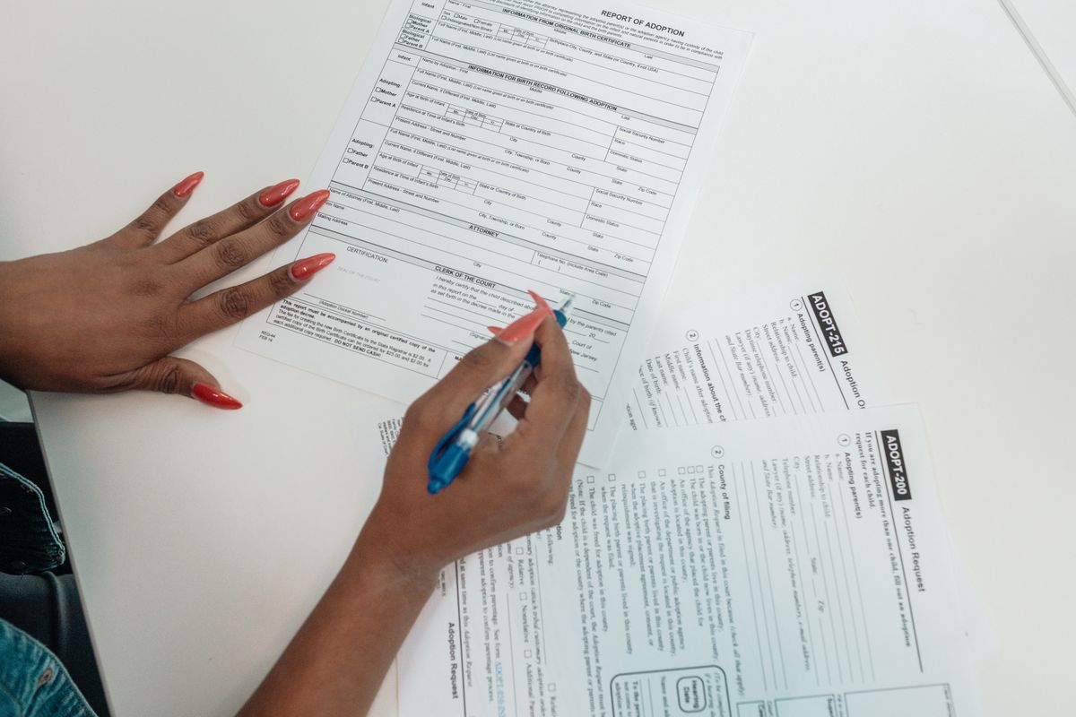 A person filling out a Social Security disability application form by hand