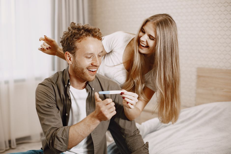 Couple celebrating a positive pregnancy test result after fertility treatment