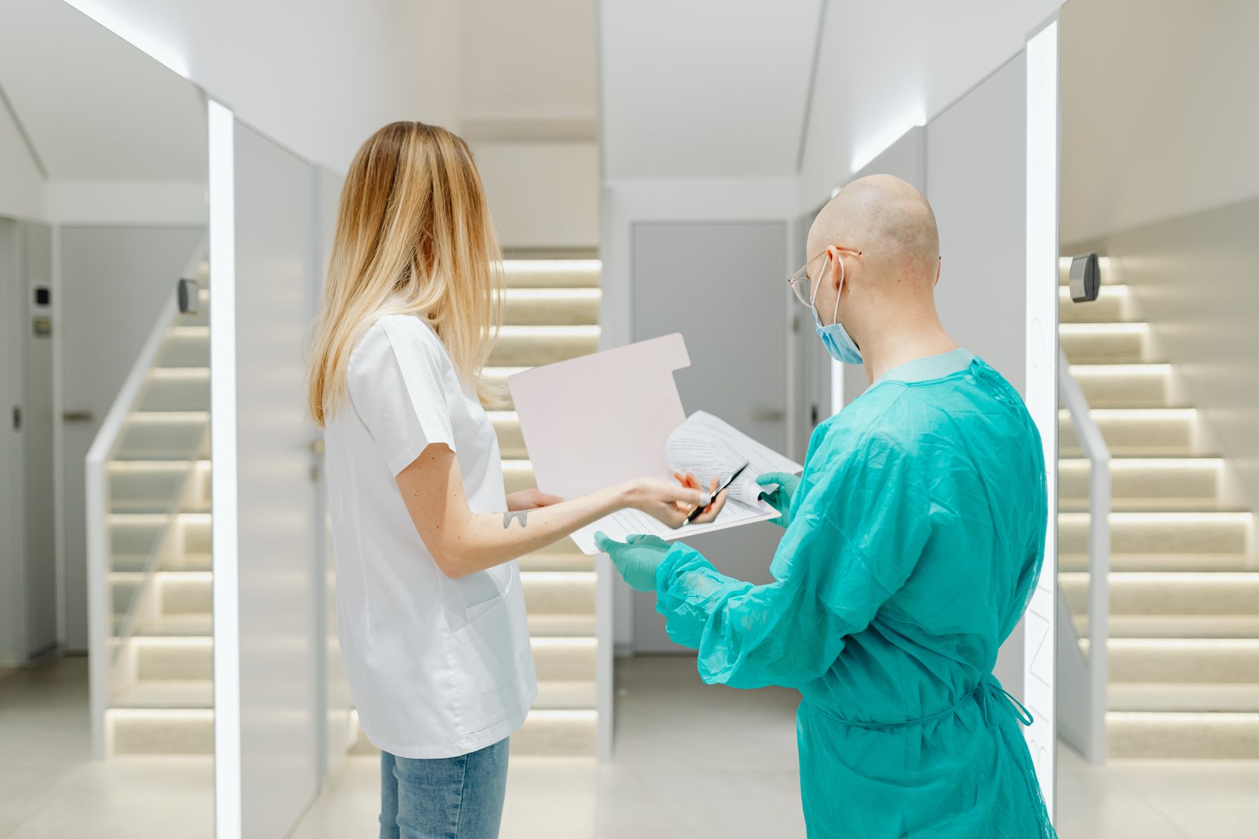 Doctors collaborating in a bright clinic hallway, discussing patient care
