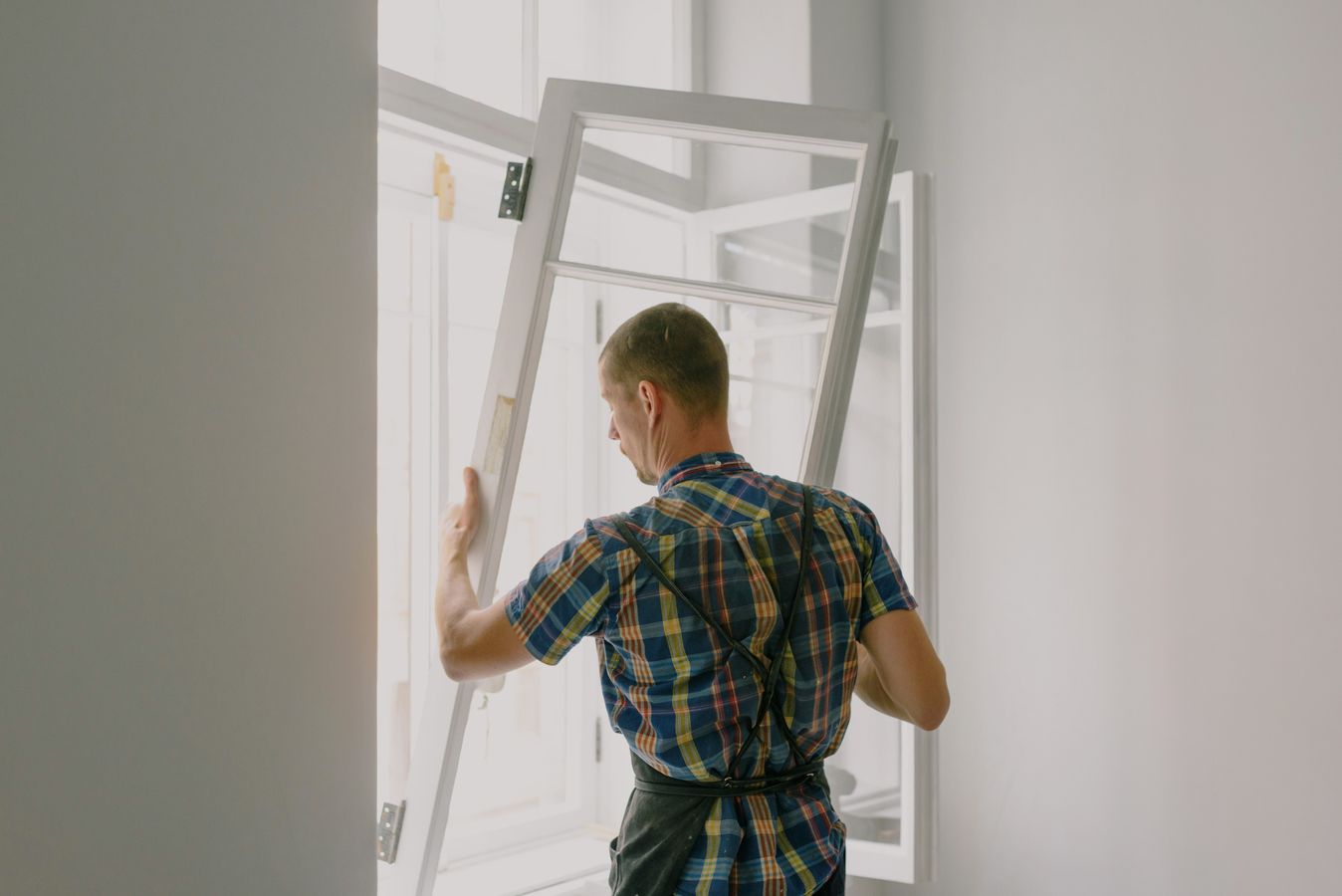 Installer mounting a new window frame inside a home during a renovation