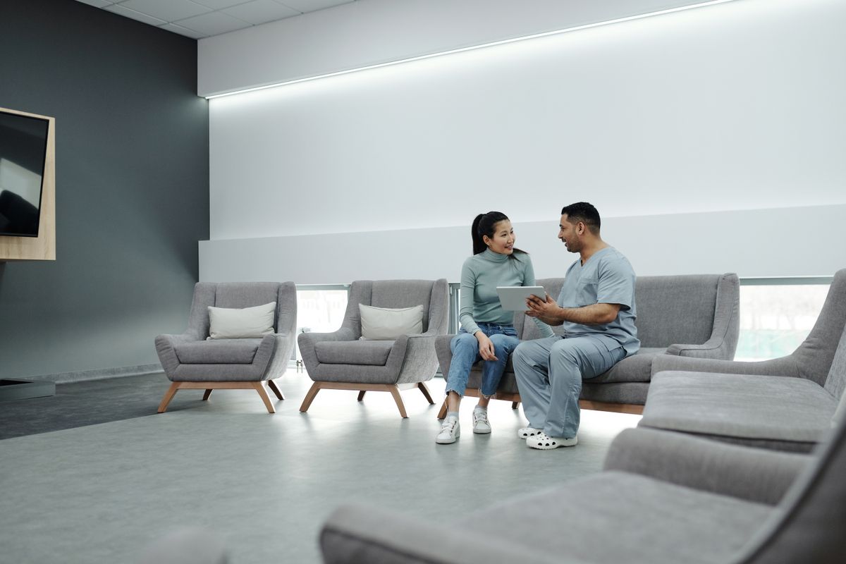 A doctor and patient discussing a concierge medicine marketing membership plan together in a modern clinic lounge