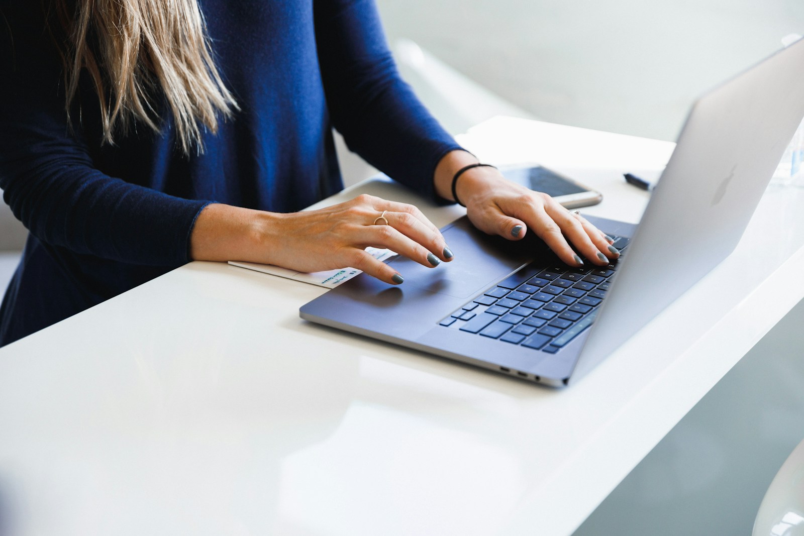 Hands typing on a laptop while researching allergy content topics