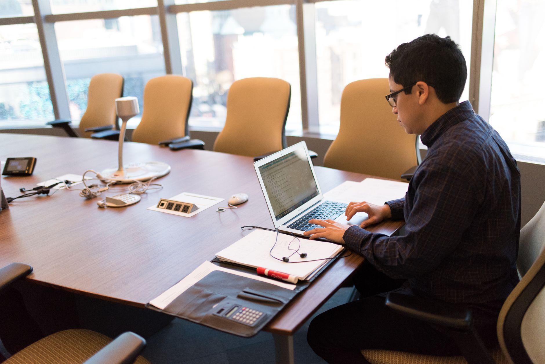 Person typing on a laptop at a desk, drafting website content
