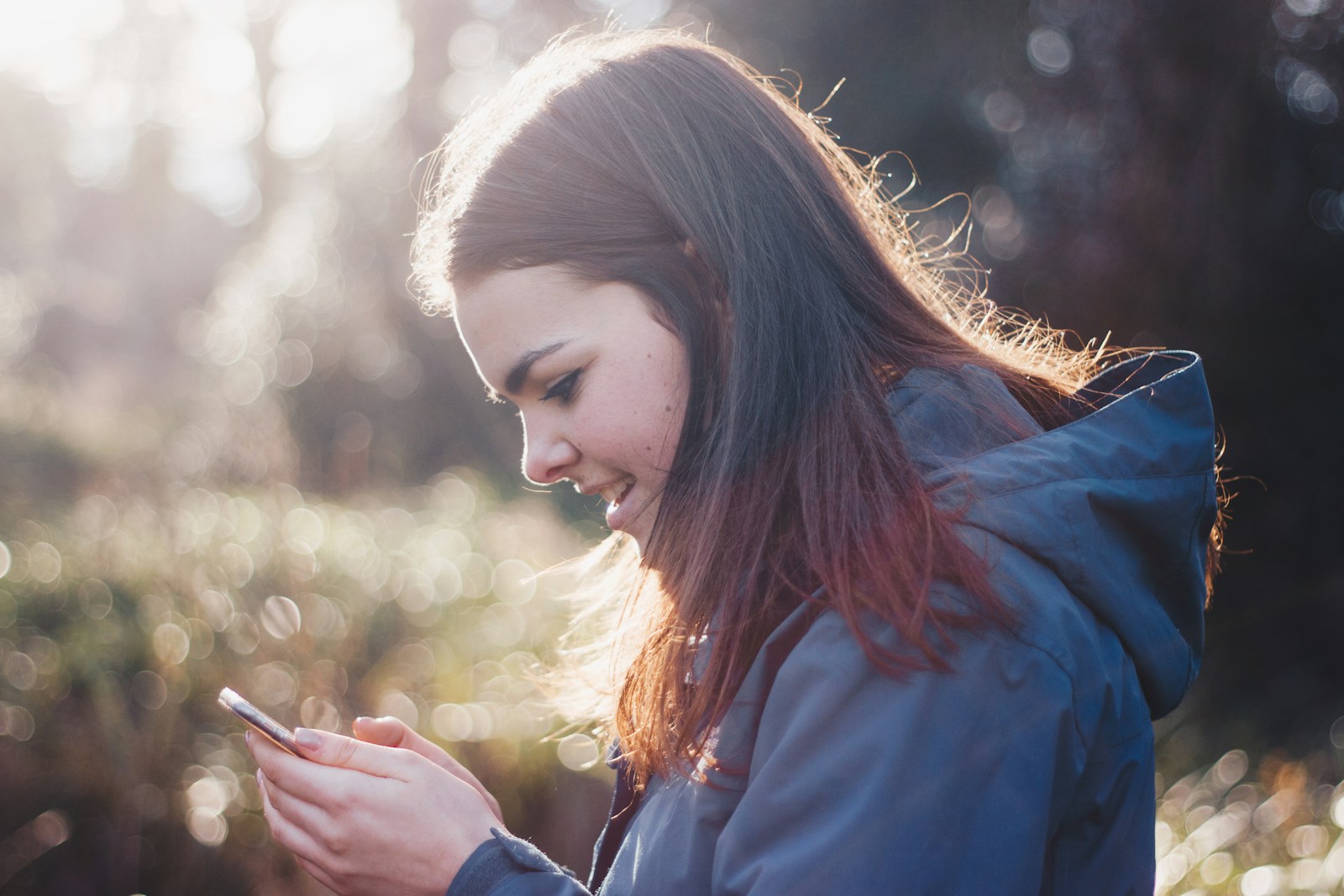 Person smiling while reading search results on a smartphone outdoors