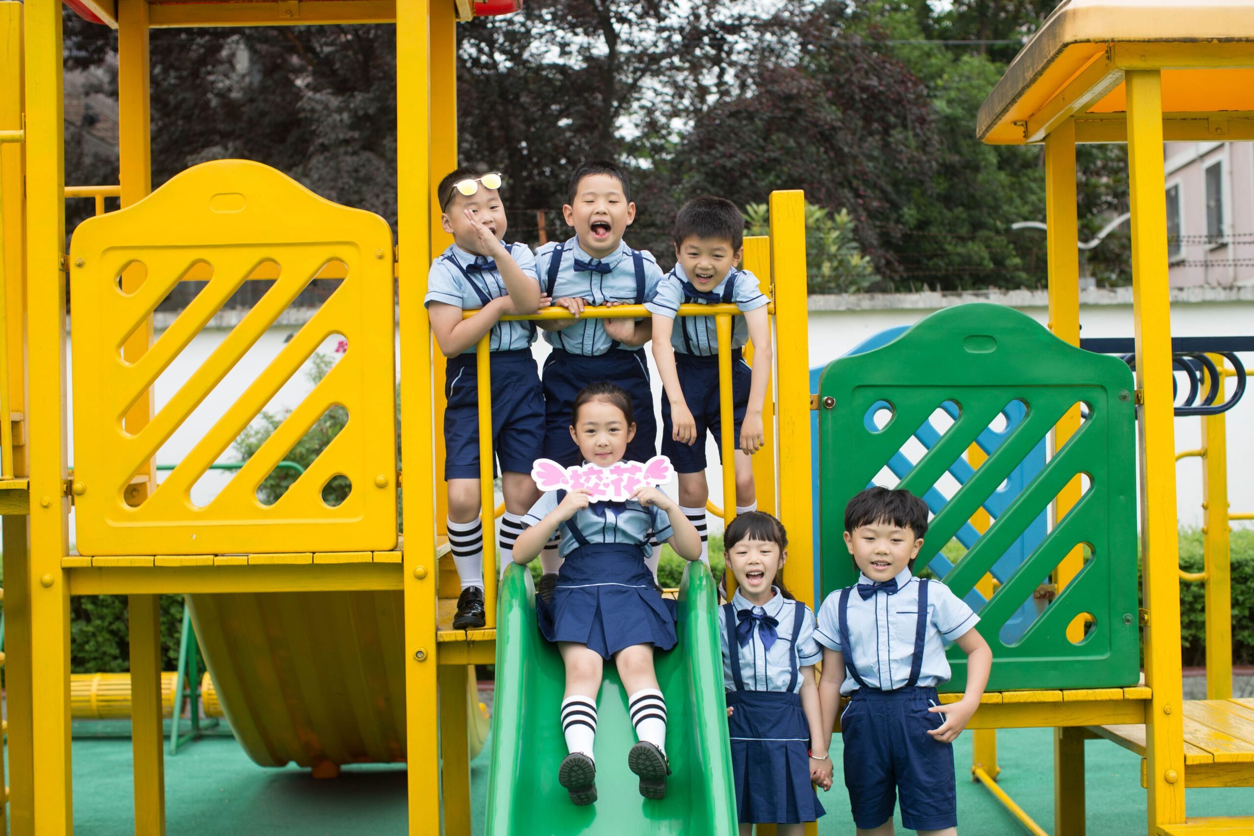 Group of preschool children playing on outdoor playground equipment