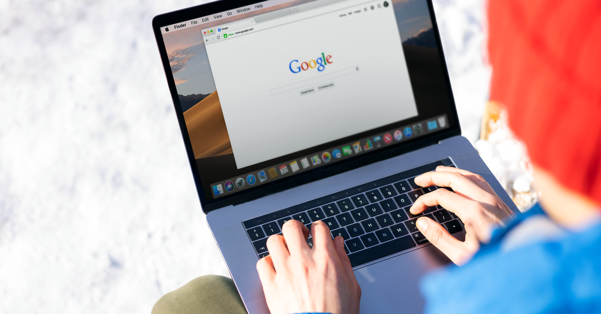 Close-up of hands researching keywords and search terms on a laptop