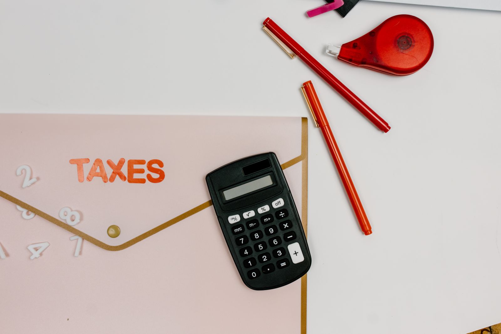 Tax forms and a calculator spread across a desk during return preparation