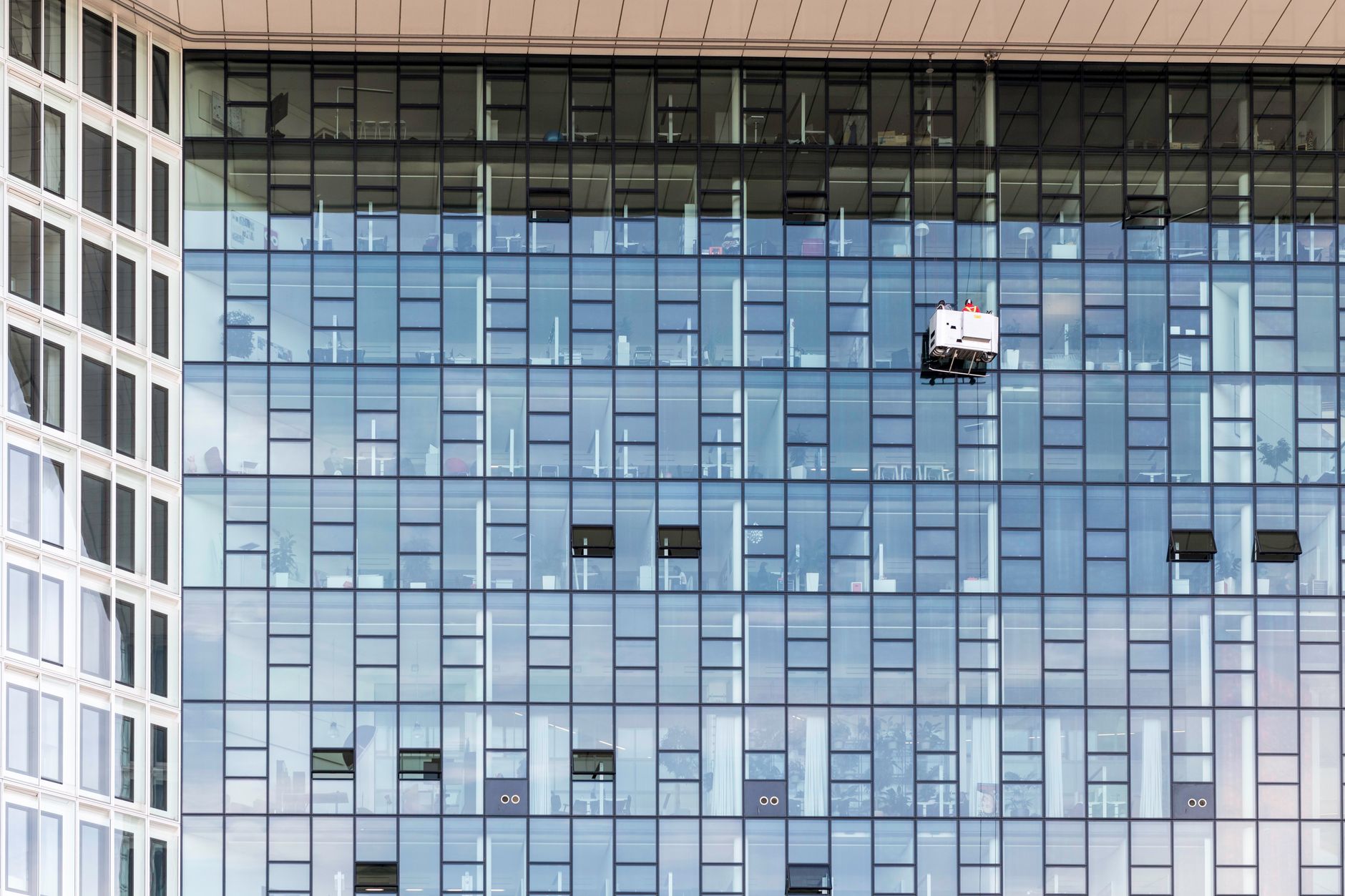 A multi-story commercial office building with a glass curtain wall facade